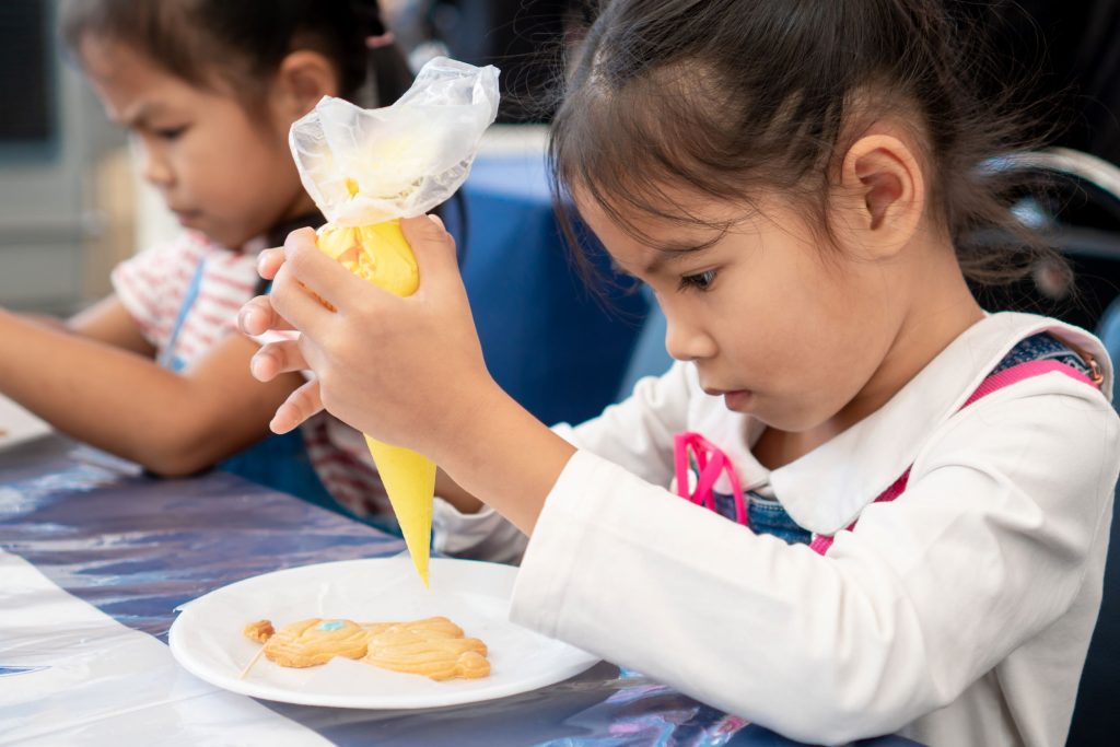 Children creatively decorating cupcakes at a party