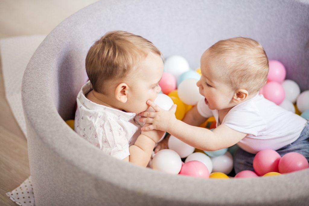 Babies enjoying sensory play in a ball pit