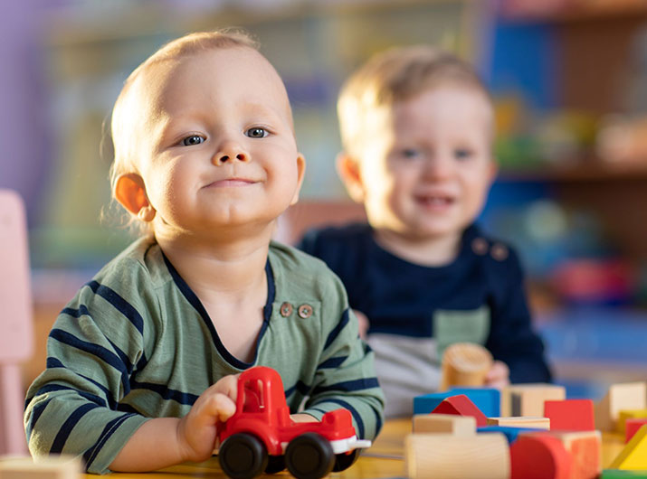 Baby reaching for toys on a play mat