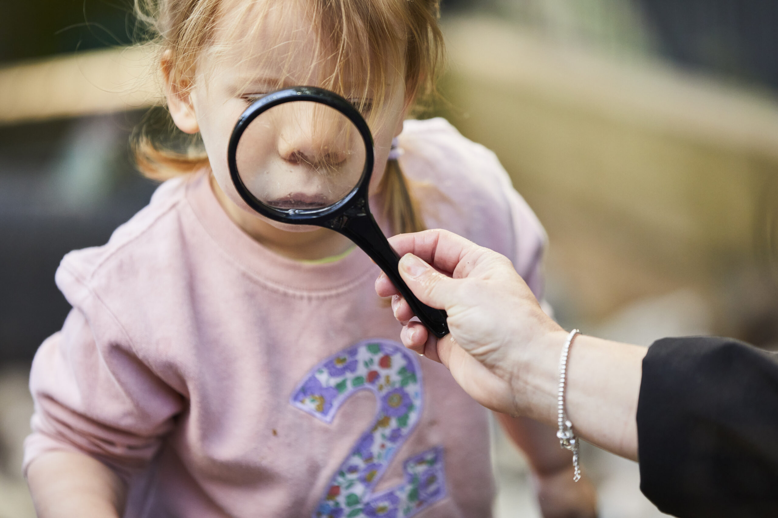 image of a girl staring through a magnifying glass