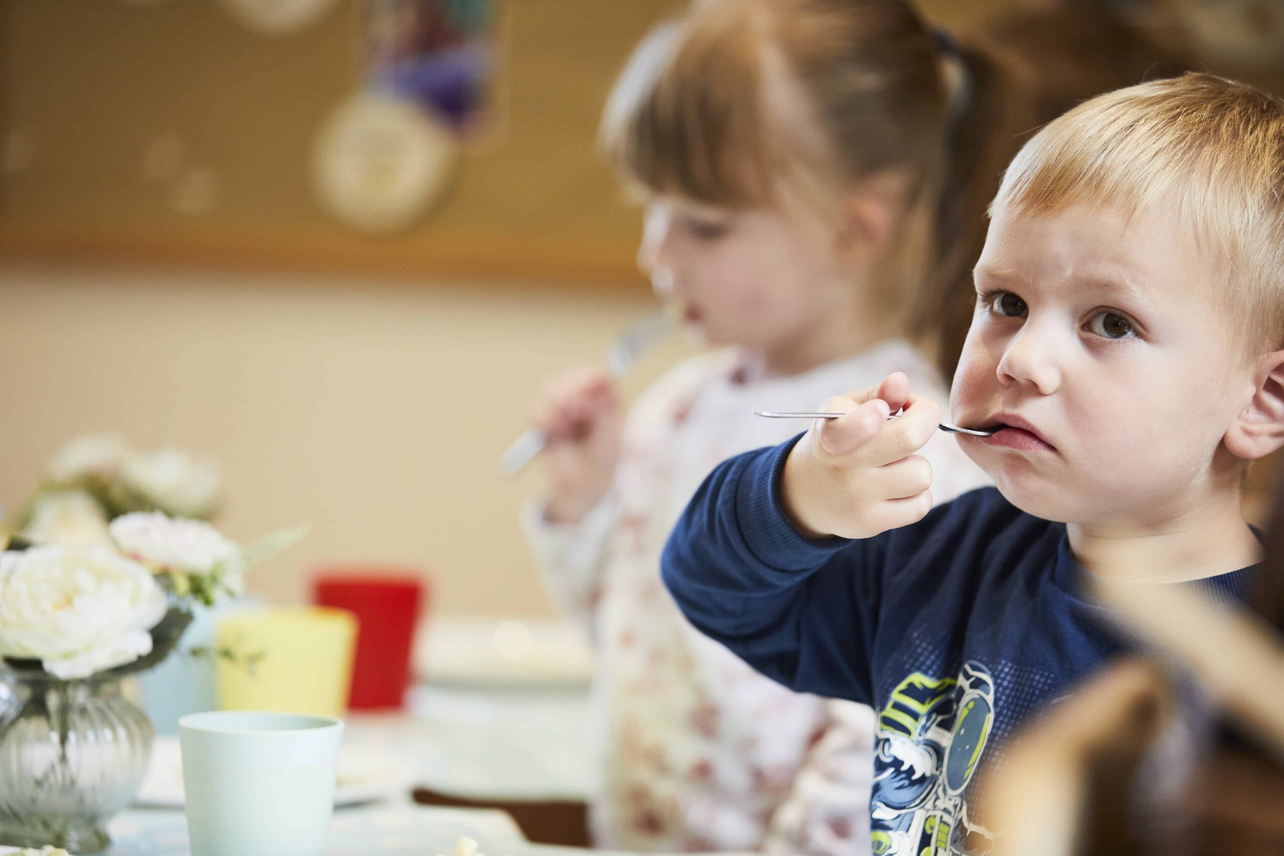 image of 2 infants eating at mealtime in the nursery dining room