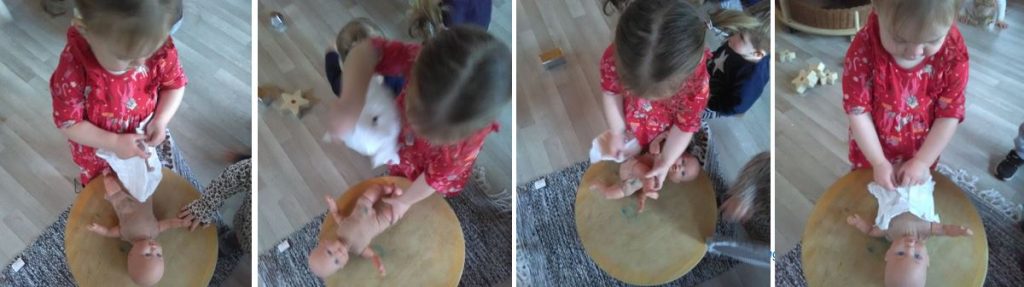 Child learning to change a doll's nappy